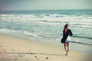 Kvinde alene på strand efter utroskab